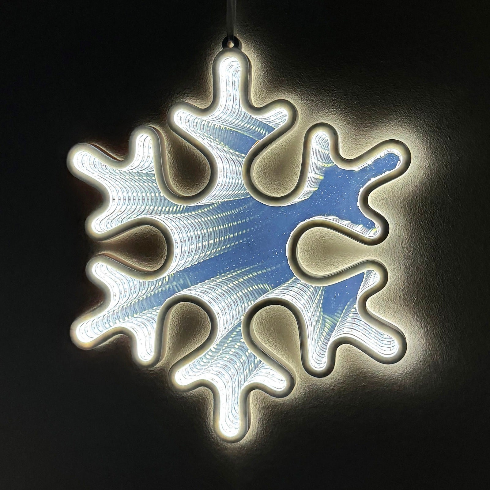 Snowflake infinity mirror light for Christmas decor, featuring LED lights with an endless depth effect. USB powered, perfect for hanging on the wall or around the Christmas tree, adding a festive glow to holiday decorations indoors.